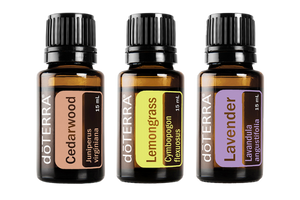 Three bottles of doTERRA essential oils labeled cedarwood, lemongrass, and lavender, displayed against a white background. Each bottle is dark brown with black caps and contains some of the
