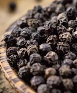 A close-up of Pure & Natural Black Pepper Essential Oil Antibacterial - 5ml in a woven basket with a blurred background, hinting at the presence of essential oils in Australia.