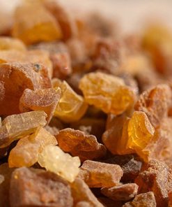 Close-up image of coarse, crystalline amber and brown rock sugar, with light highlighting the translucent and rough textures of the sugar crystals, reminiscent of the rich hue of Myrrh Versatile Essential Oil - 15 ml.