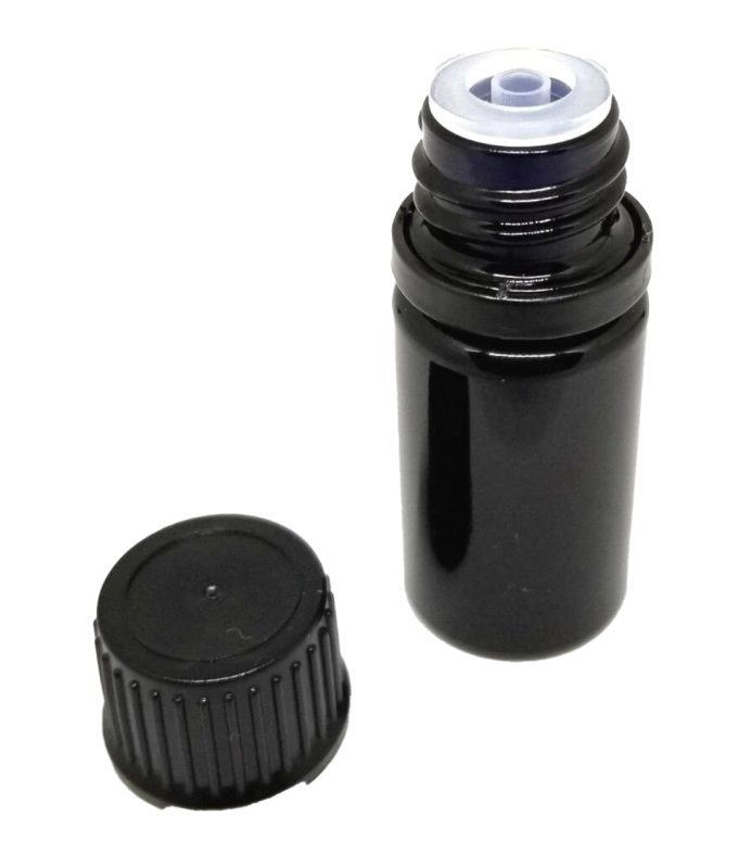 A small black film canister with a transparent blue lid partially connected, placed next to its black cap, isolated on a white background. Inside the canister are natural essentials oil samples.