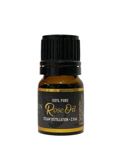 Sentence with product name: A small bottle of Rose Fragrance Oil | Perfume Oil – 100% Pure labeled "rose oil" with "steam distillation" and "2.5 ml" noted on the label, set against a plain white background
